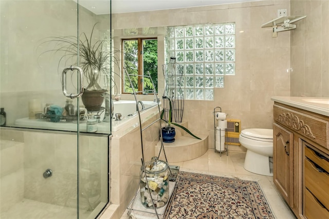 full bathroom with tile walls, toilet, vanity, tile patterned flooring, and a garden tub
