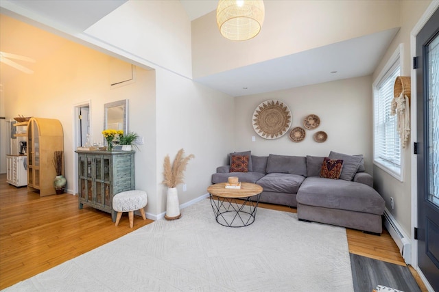323 New York Ave, Long Beach, NY 11561 - living room featuring baseboards, ceiling fan, a baseboard heating unit, and wood finished floors