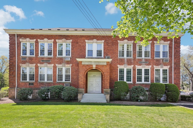 view of front of property featuring brick siding and a front yard