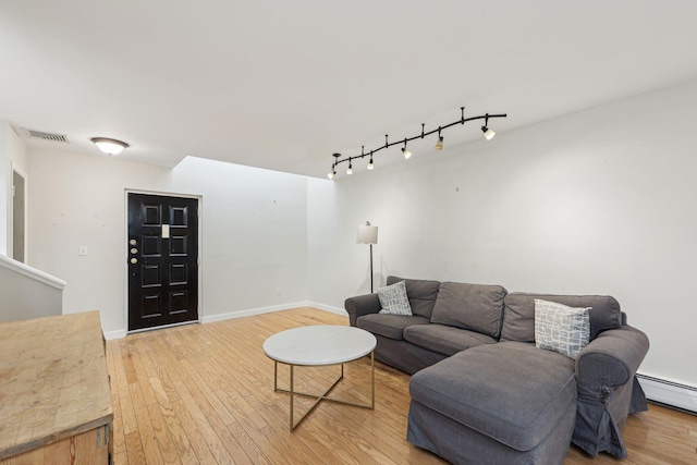 living room with visible vents, track lighting, baseboards, light wood-type flooring, and a baseboard heating unit