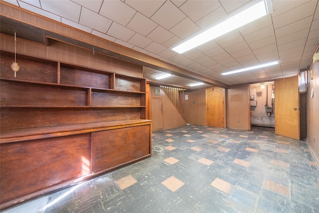 finished below grade area with wooden walls and tile patterned floors