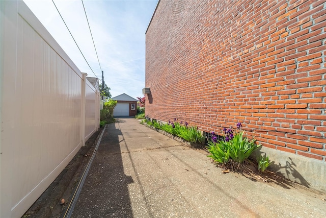 view of side of home featuring an outbuilding and brick siding