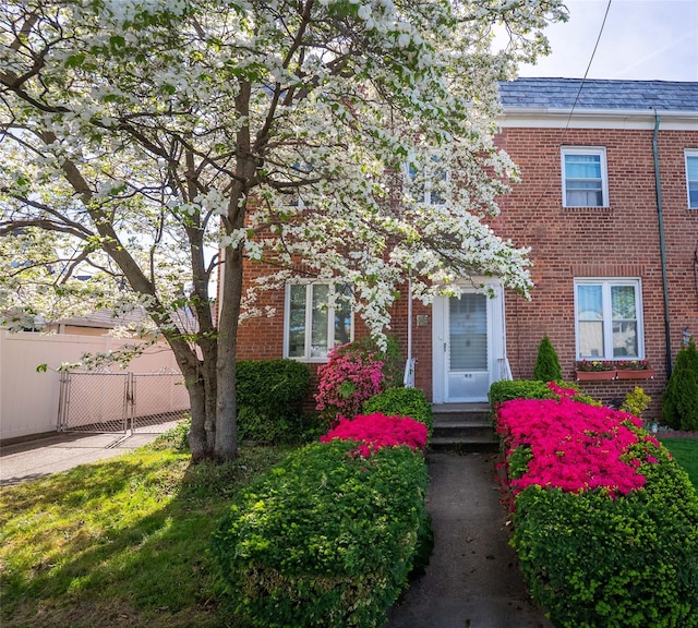 multi unit property with fence, entry steps, and brick siding