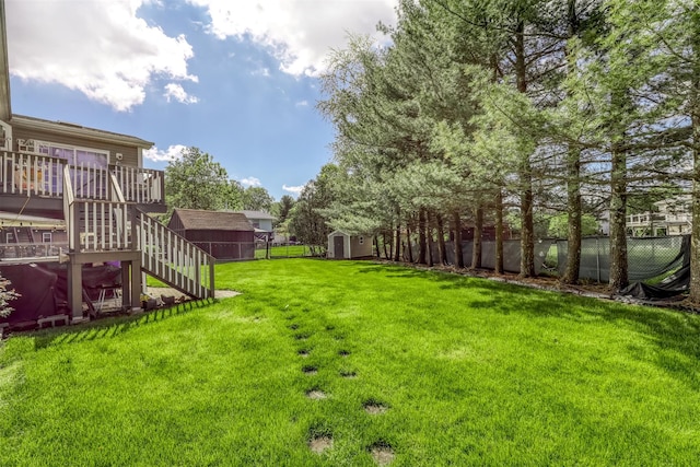 view of yard with a storage shed, stairway, an outbuilding, and a deck