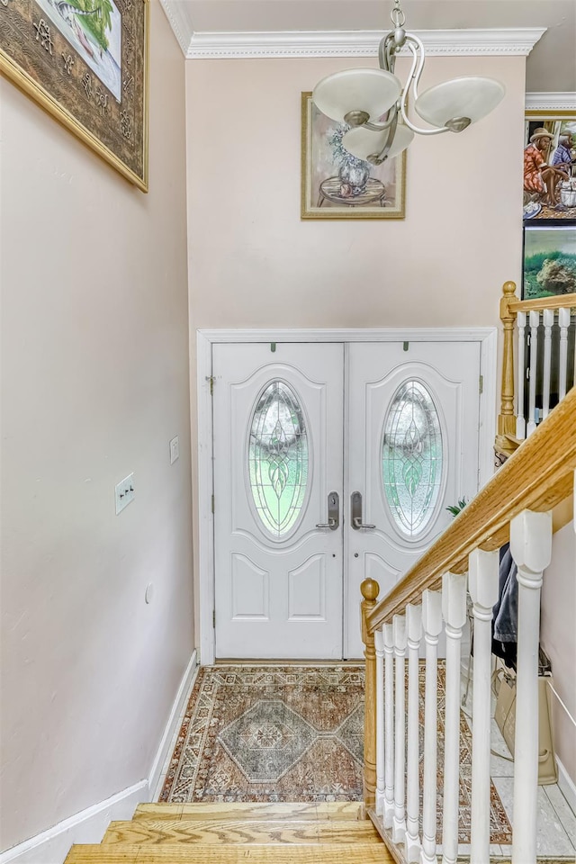 foyer featuring baseboards and ornamental molding