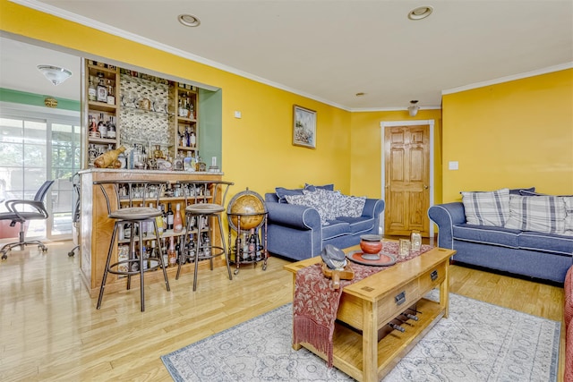 living area featuring crown molding, wood finished floors, a dry bar, and recessed lighting