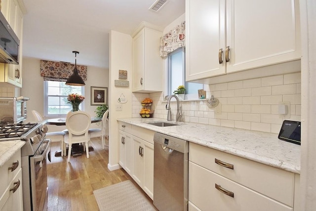 800 Commons Way Unit B, Fishkill, NY 12524 - kitchen with stainless steel appliances, light wood-type flooring, a sink, white cabinetry, and hanging light fixtures