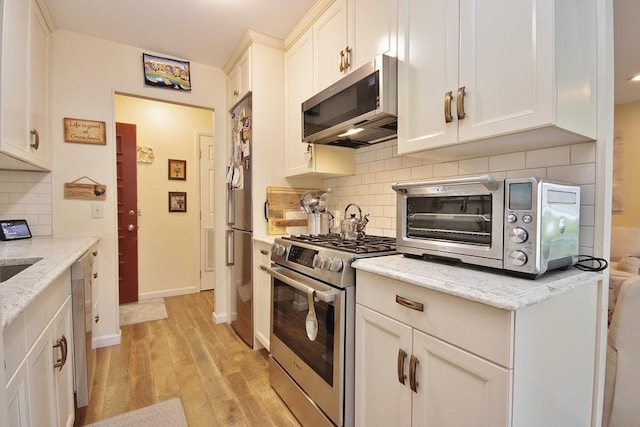 800 Commons Way Unit B, Fishkill, NY 12524 - kitchen featuring appliances with stainless steel finishes, light wood-style floors, white cabinetry, and decorative backsplash
