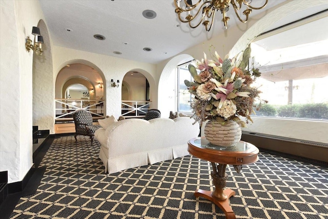 bedroom featuring carpet floors, a textured wall, and a chandelier