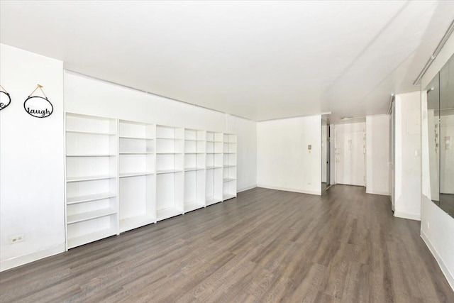 unfurnished living room featuring baseboards and wood finished floors