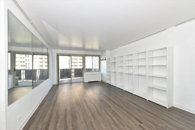interior space with baseboards and dark wood-type flooring