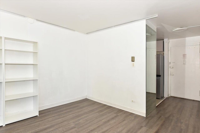 spare room featuring baseboards and wood finished floors
