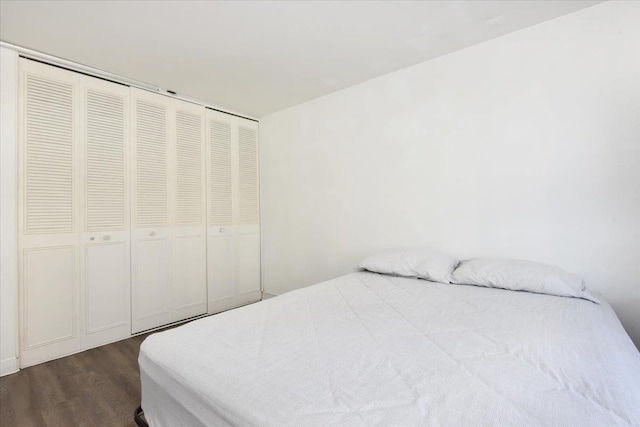 bedroom with dark wood-style floors and a closet