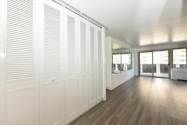 hallway with dark wood finished floors and radiator heating unit