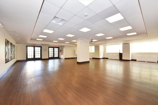 unfurnished room with baseboards, dark wood-style floors, and a paneled ceiling