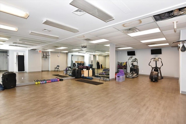 workout area with visible vents, baseboards, and wood finished floors