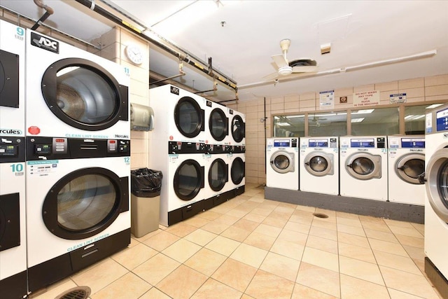 shared laundry area with washing machine and clothes dryer, a ceiling fan, stacked washer / drying machine, and tile patterned flooring