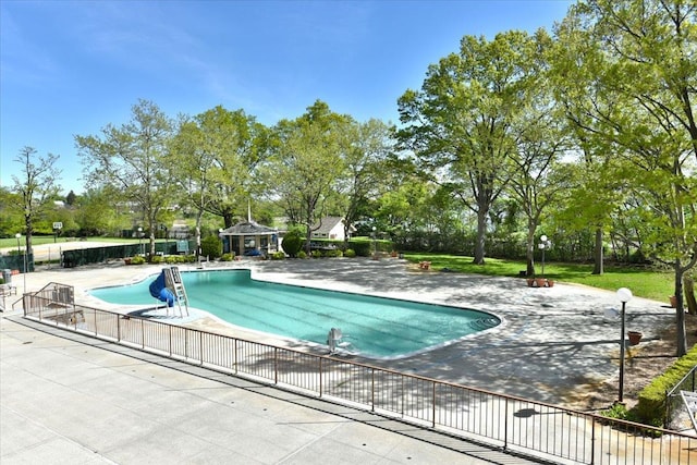community pool with fence and a patio area