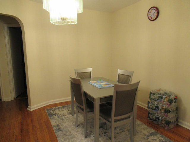3248 Hone Ave, Bronx, NY 10469 - dining room featuring a chandelier, arched walkways, baseboards, and wood finished floors