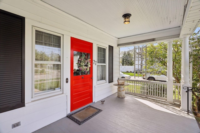 doorway to property with a porch and visible vents