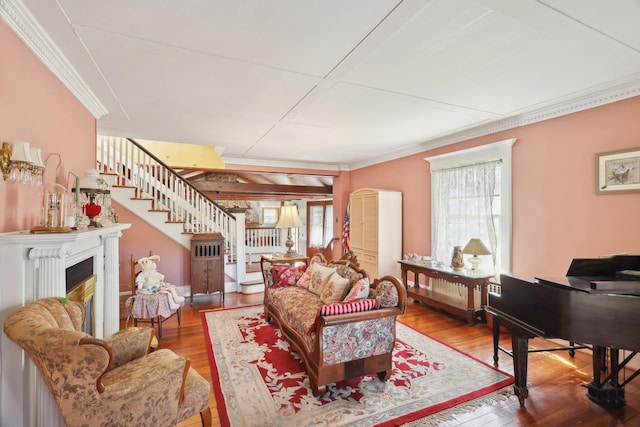 living room with ornamental molding, wood finished floors, and stairway