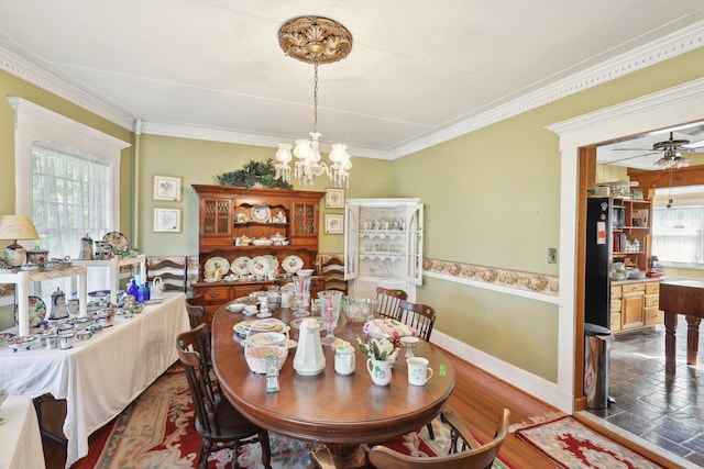 dining area featuring baseboards, ornamental molding, and ceiling fan with notable chandelier