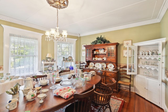 dining room featuring ornamental molding, wood finished floors, and a notable chandelier