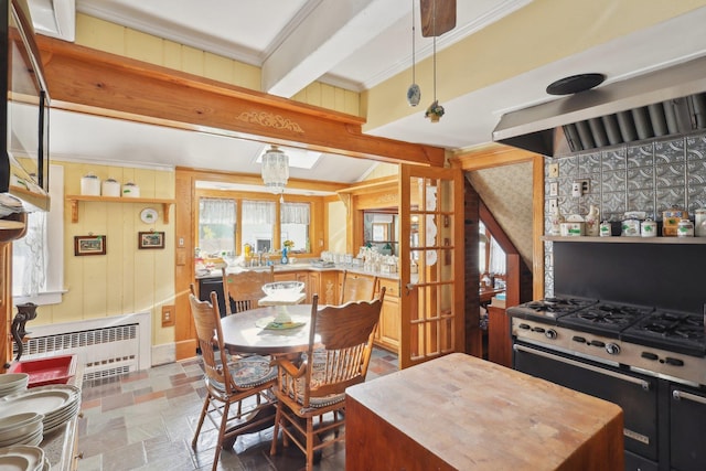 kitchen with crown molding, radiator, stone finish floor, and a center island