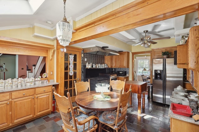 dining space with ornamental molding, stone finish flooring, ceiling fan, and vaulted ceiling