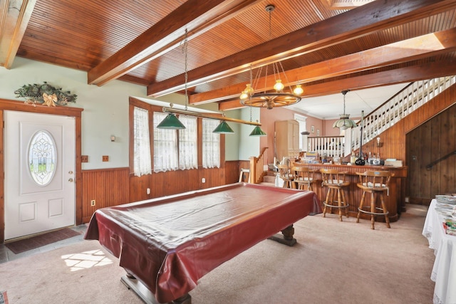 playroom featuring wooden walls, carpet flooring, a wainscoted wall, beamed ceiling, and a bar