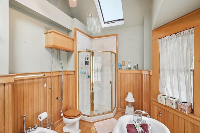full bathroom featuring wainscoting, a tub to relax in, a bidet, lofted ceiling with skylight, and a stall shower