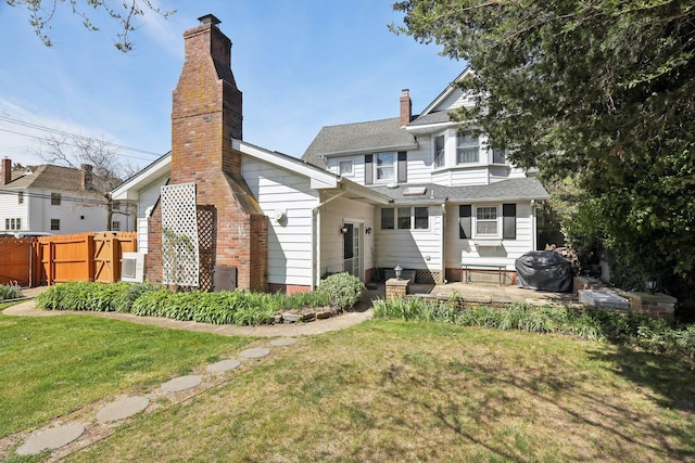 back of property with fence, a yard, and a patio area
