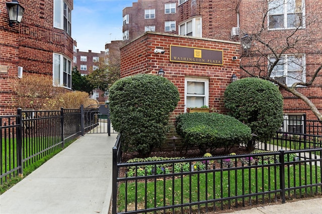view of side of home featuring a fenced front yard and brick siding