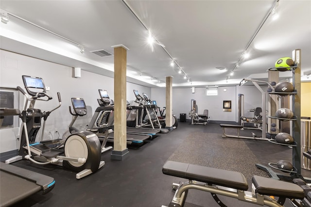 exercise room with visible vents and rail lighting