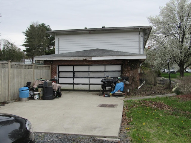 garage featuring fence and driveway