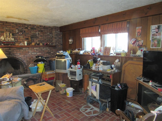 living area with wood walls, brick floor, and a textured ceiling