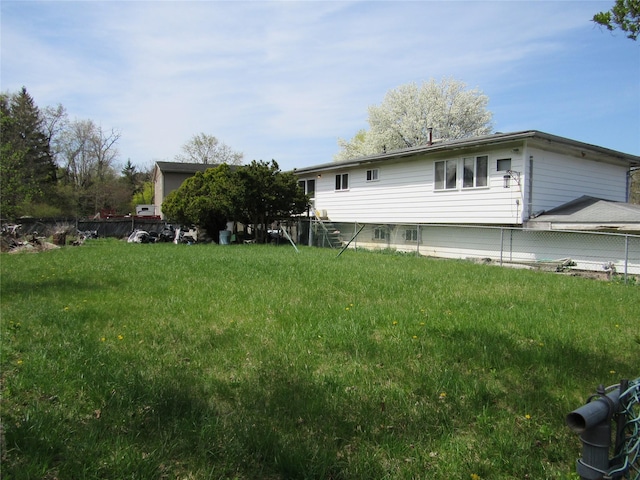 exterior space with fence and a lawn