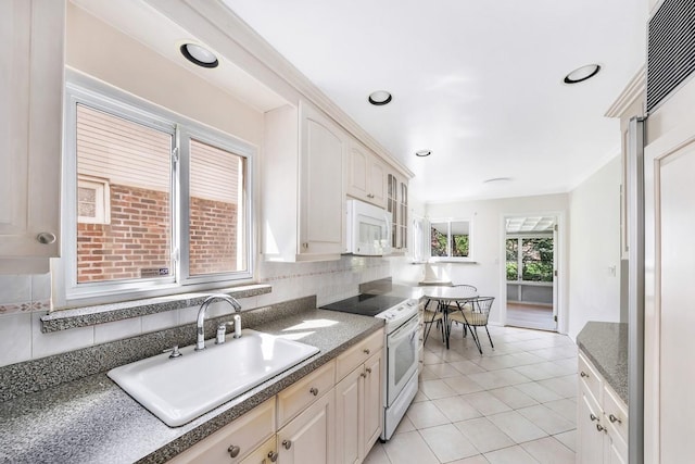 kitchen with white appliances, glass insert cabinets, light tile patterned floors, a sink, and backsplash