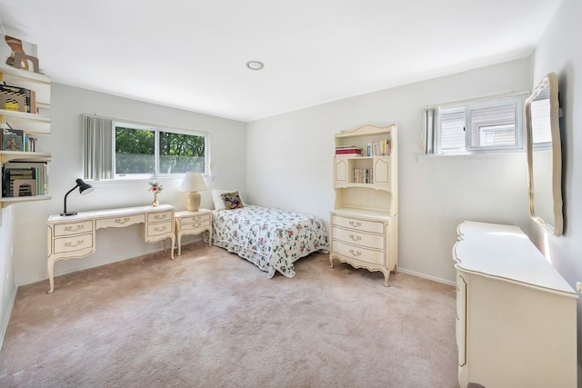 bedroom with baseboards, light carpet, and multiple windows