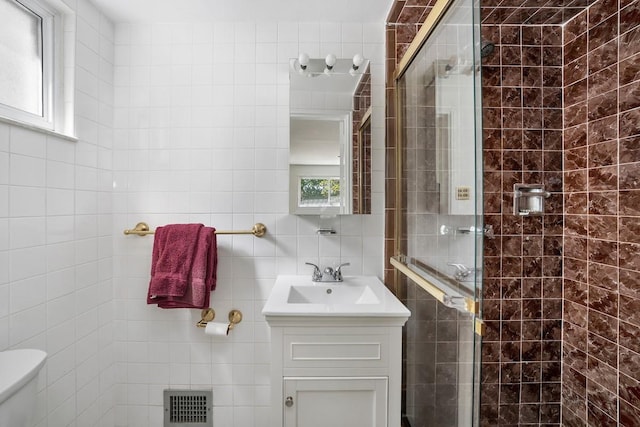full bath featuring tile walls, plenty of natural light, and a stall shower