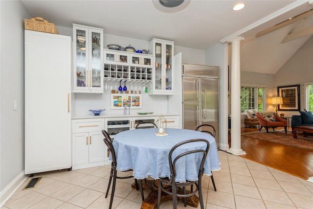 dining room with decorative columns, a dry bar, light tile patterned floors, recessed lighting, and baseboards