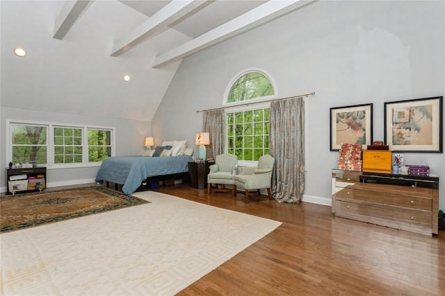bedroom with multiple windows, wood finished floors, baseboards, recessed lighting, and beamed ceiling