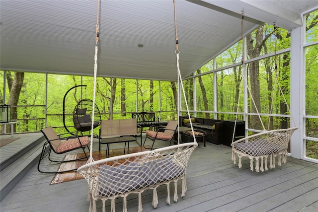 sunroom featuring an outdoor hangout area, outdoor dining area, and lofted ceiling