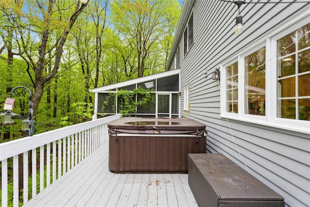 wooden terrace with a hot tub and a sunroom