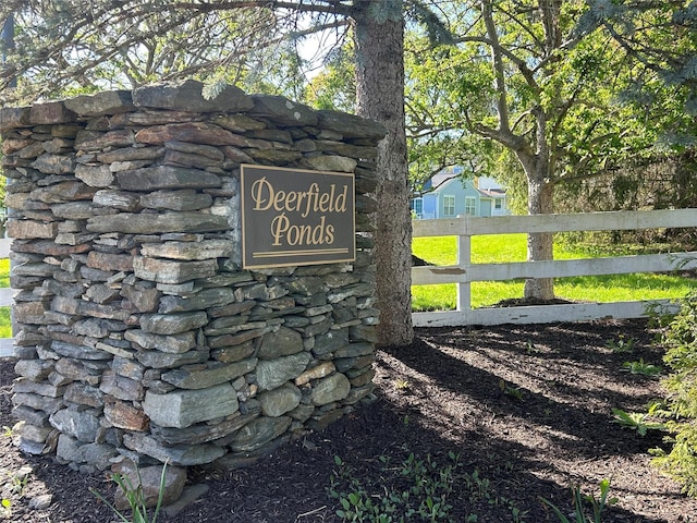 community / neighborhood sign featuring fence