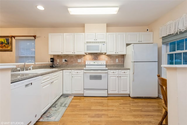 kitchen featuring a sink, white cabinets, and white appliances