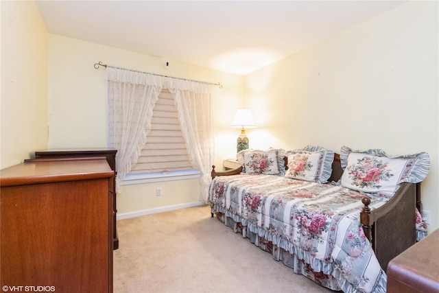 bedroom with baseboards and light carpet