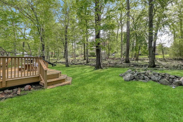 view of green lawn with a wooden deck