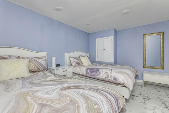bedroom featuring marble look tile flooring