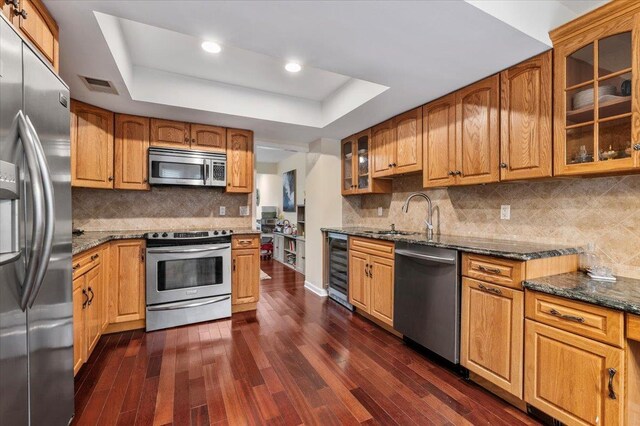 kitchen featuring a tray ceiling, appliances with stainless steel finishes, visible vents, and wine cooler